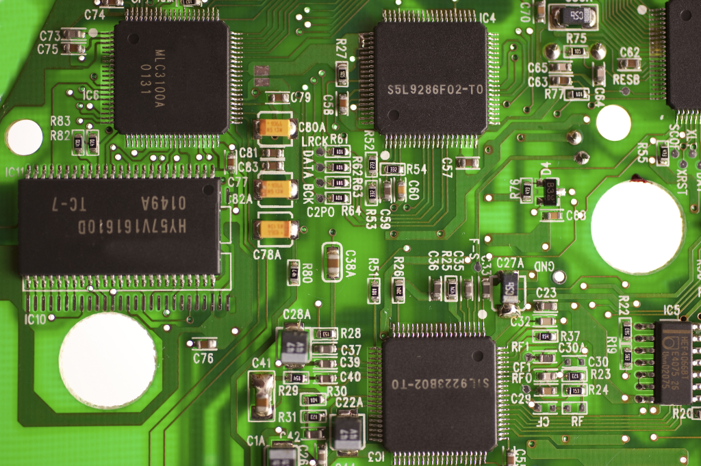 Close-up View of a Green Printed Circuit Board with Multiple Integrated Circuits, Resistors, and Capacitors. Embracing Green It Principles, the Components Are Intricately Connected by Thin Conductive Traces.