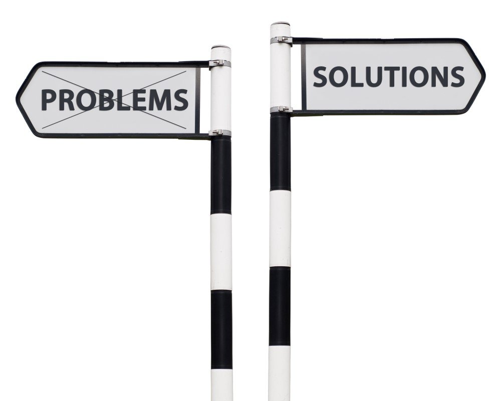 Two Signposts Point in Opposite Directions. the Left Sign Reads "problems" with an X over It, While the Right Sign Directs You Towards "it Solutions" Without an X.