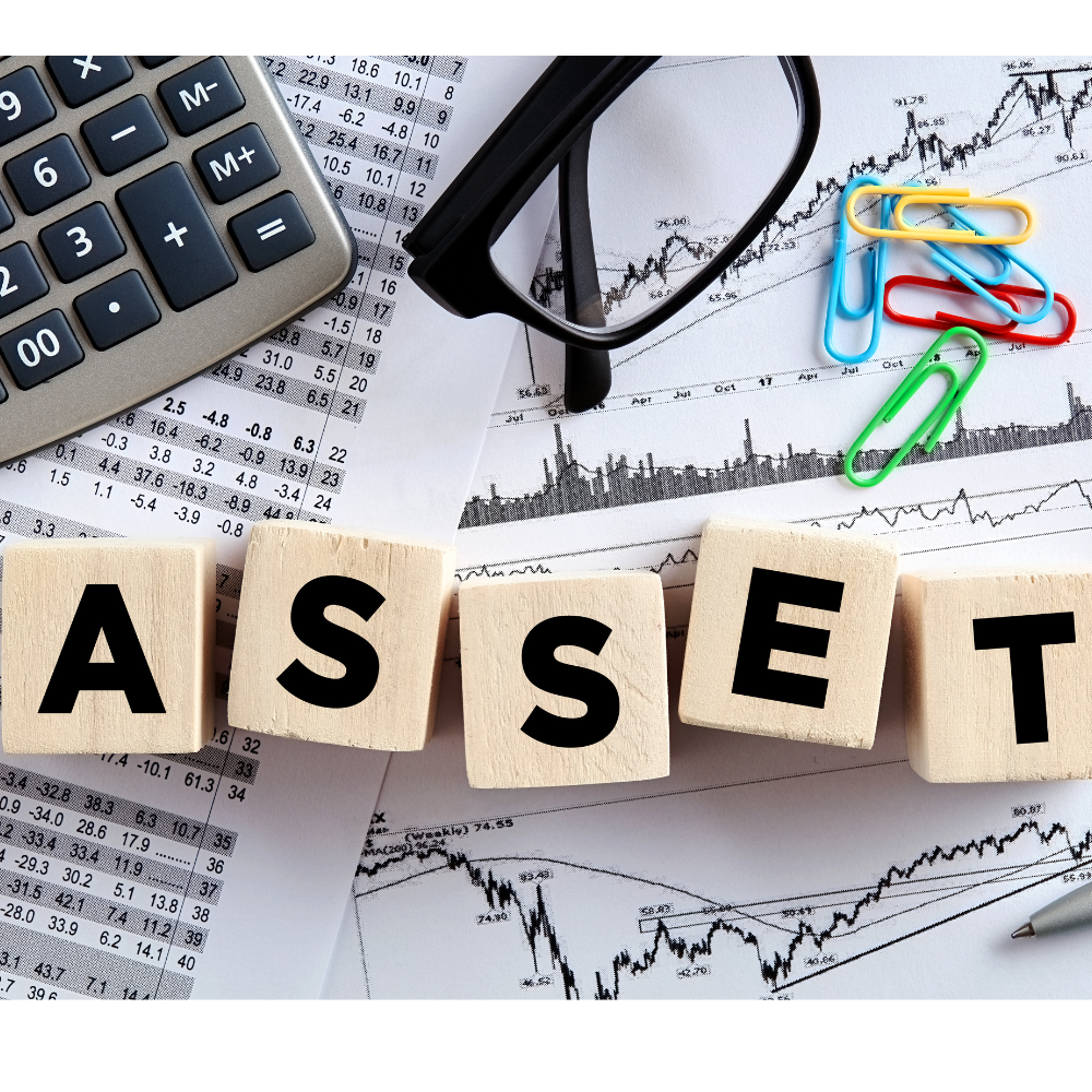 Wooden Blocks Spelling "asset" on Financial Documents with Graphs, a Calculator, Glasses, Colorful Paper Clips, and an Itam Report in the Background.