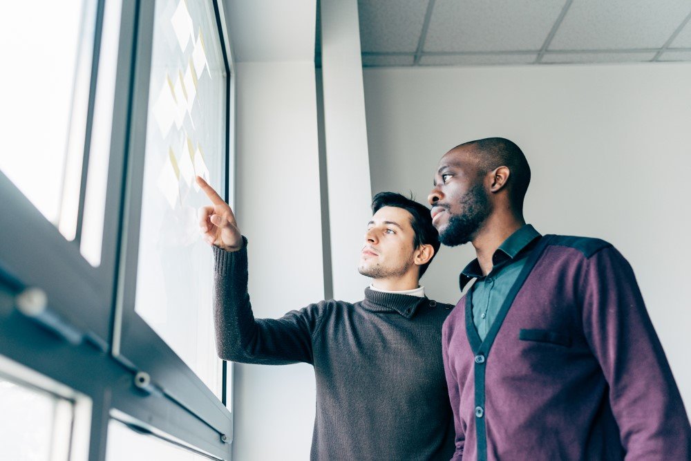 Two Men Discussing It Consulting Information Presented on a Screen.