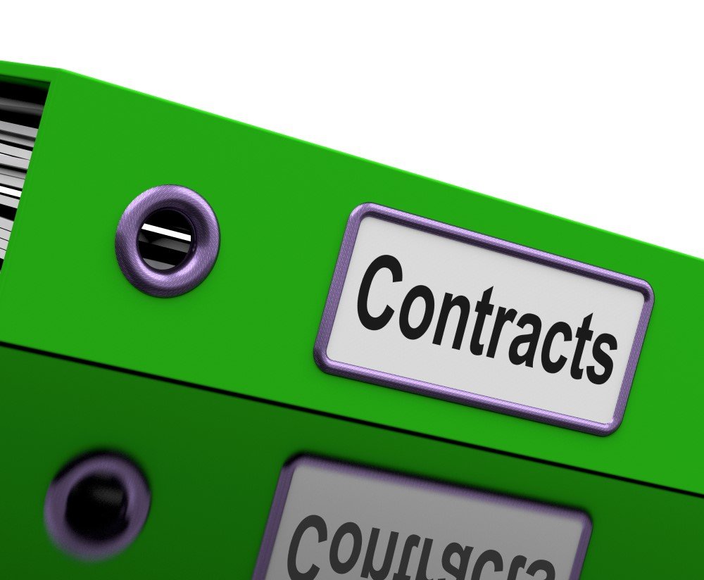 a Green Binder Labeled “contracts” Lies on a Reflective Surface, Indicative of the Meticulous Preparation for Contract Bidding.