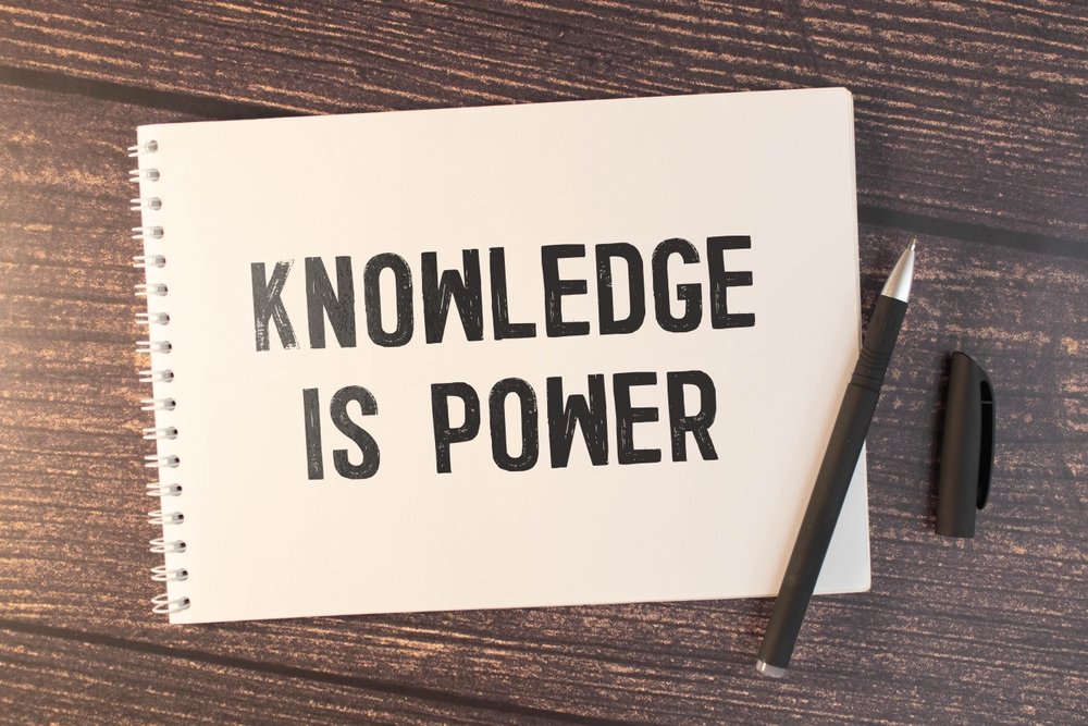 a Notebook on a Table with the Phrase "knowledge is Power" Written on Its Cover, Next to a Pen and Pen Cap—an Essential Tool for Gaining Knowledge.